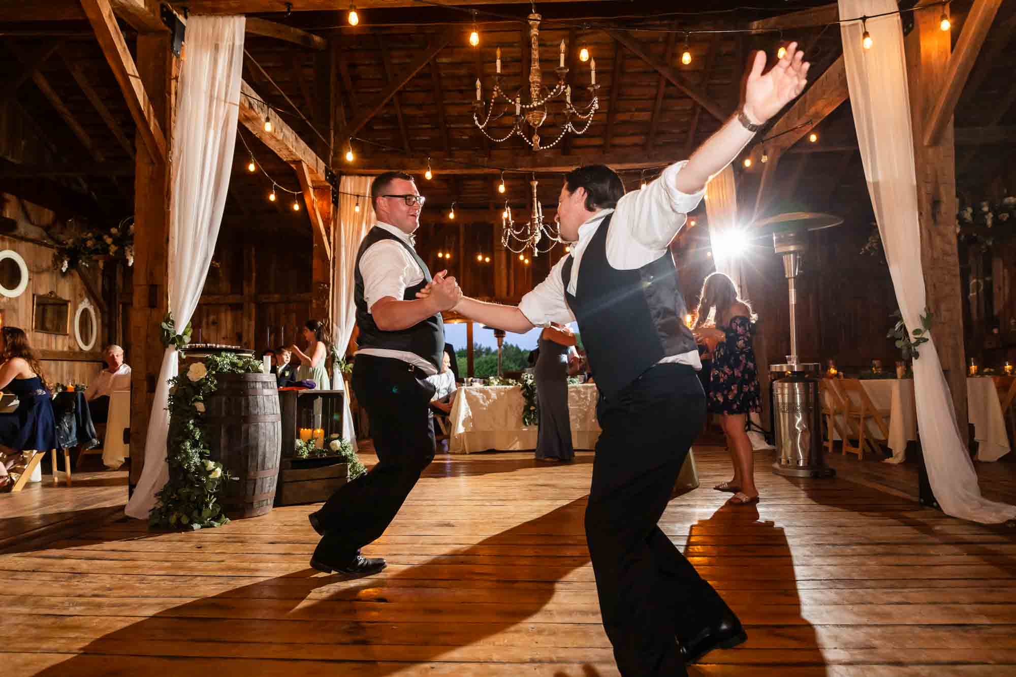 groomsmen and groom dance together wildly at the wedding reception at pinehall at eisler farm